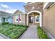 Inviting front entrance with a brick paved walkway, colorful landscaping, and a classic American flag at 1219 Victoria Hills N Dr, Deland, FL 32724