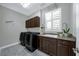 Laundry room with modern washer and dryer, storage cabinets, and granite countertops at 1219 Victoria Hills N Dr, Deland, FL 32724