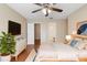 Cozy main bedroom with hardwood floors, ceiling fan, and view into ensuite bathroom at 1222 Madelena Ave, Winter Springs, FL 32708