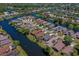 Aerial view showcasing home in a lakeside community with mature trees, green lawns, and well-maintained streets at 133 Wood Ibis Ct, Daytona Beach, FL 32119