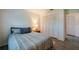 Neutral-toned bedroom features an organized closet, side table and lamp at 133 Wood Ibis Ct, Daytona Beach, FL 32119