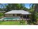 A serene backyard featuring a private pool, mature trees, and a cozy pergola-covered patio at 150 Lake Charles Rd, Deland, FL 32724