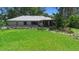 Backyard featuring lush green lawn, mature trees, and a charming home with a serene outdoor ambiance at 150 Lake Charles Rd, Deland, FL 32724