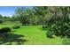Expansive lush backyard with mature trees offers a serene retreat by the water with a beautiful lawn at 150 Lake Charles Rd, Deland, FL 32724