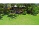View of backyard shed on property amidst green grass and trees providing additional storage and utility at 150 Lake Charles Rd, Deland, FL 32724
