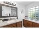 A full guest bathroom with cherry cabinets, a vanity with plenty of storage, and a glass block window at 150 Lake Charles Rd, Deland, FL 32724
