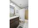 A full guest bath with a vanity with plenty of storage, a toilet and shower/tub combo behind a curtain at 150 Lake Charles Rd, Deland, FL 32724