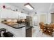Bright eat-in kitchen with modern stainless steel appliances, breakfast bar seating, and access to the laundry room at 150 Lake Charles Rd, Deland, FL 32724