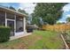 View of the backyard featuring a screened-in patio, lush lawn, and a wood privacy fence at 1504 Ginger Snap, Deland, FL 32720