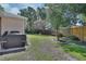 Spacious backyard featuring a lush green lawn, mature trees, privacy fence, and outdoor grill area at 1504 Ginger Snap, Deland, FL 32720