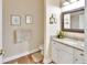 Bathroom featuring a granite countertop, vanity and framed mirror, complemented by hardwood floors at 1504 Ginger Snap, Deland, FL 32720