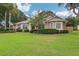 Charming single-story home with lush landscaping and a manicured lawn under a bright blue, partially cloudy sky at 1504 Ginger Snap, Deland, FL 32720