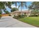 Well-maintained home with a long driveway, lush landscaping, and a welcoming facade under a partly cloudy sky at 1504 Ginger Snap, Deland, FL 32720