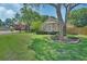 Well-manicured front yard featuring lush green lawn, a large tree, and beautifully maintained landscaping at 1504 Ginger Snap, Deland, FL 32720