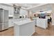 Bright kitchen featuring stainless steel appliances, white cabinets, a large island, and hardwood floors at 1504 Ginger Snap, Deland, FL 32720