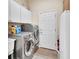 Functional laundry room featuring modern washer, dryer, white cabinets, and ample storage space at 1504 Ginger Snap, Deland, FL 32720