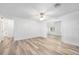 An open concept living area features wood-look flooring, ceiling fan, and bright white walls at 1534 Center St, Deland, FL 32720
