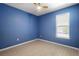 A bedroom with blue walls, a window, a ceiling fan and tile floors at 1613 Lady Fern Trl, Deland, FL 32720