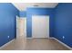 A bedroom with blue walls, tile floors, a closet, and a door to another room at 1613 Lady Fern Trl, Deland, FL 32720