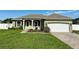 Well-maintained one-story home featuring a two-car garage, and a green lawn with a walkway at 1613 Lady Fern Trl, Deland, FL 32720