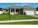 Charming single-story home with manicured lawn, a two-car garage, and a bright green front door at 1613 Lady Fern Trl, Deland, FL 32720