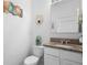 A clean powder room featuring a vanity with granite countertop and modern decorative elements at 1655 Pham Dr, Port Orange, FL 32129