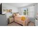 Cozy bedroom with natural light, featuring a comfortable bed, dresser, and window with sheer curtains at 1655 Pham Dr, Port Orange, FL 32129