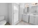 Bright bathroom featuring double sink vanity, shower, and toilet at 1842 W Cooper Dr, Deltona, FL 32725