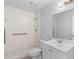 All-white bathroom with a walk-in shower, grab bars, and a single vanity sink at 1842 W Cooper Dr, Deltona, FL 32725