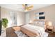 Bright bedroom features a ceiling fan, a king bed, and an ensuite bathroom at 1842 W Cooper Dr, Deltona, FL 32725