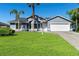Charming single-story home with a well-manicured lawn, mature palm trees, and attached two-car garage at 1842 W Cooper Dr, Deltona, FL 32725