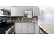 Contemporary kitchen featuring granite countertops, stainless steel appliances, and white cabinets at 1842 W Cooper Dr, Deltona, FL 32725