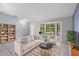 Cozy living room features a bay window, neutral-toned furniture, and a bookshelf at 1842 W Cooper Dr, Deltona, FL 32725