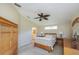 Bright, neutral bedroom featuring a bed, ceiling fan, and visible ensuite bathroom at 1860 Turnbull Lakes Dr, New Smyrna Beach, FL 32168