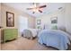 Bright bedroom showcasing two twin beds, a green dresser, and ample natural light from the window at 1860 Turnbull Lakes Dr, New Smyrna Beach, FL 32168