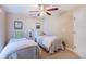 Cozy bedroom featuring two twin beds, neutral walls, and a ceiling fan for added comfort at 1860 Turnbull Lakes Dr, New Smyrna Beach, FL 32168