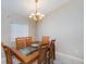 Dining area showcasing a glass-topped table with wooden chairs under a decorative chandelier at 1860 Turnbull Lakes Dr, New Smyrna Beach, FL 32168