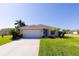 Charming single-story home with a well-manicured lawn, tropical landscaping, and a paved driveway at 1860 Turnbull Lakes Dr, New Smyrna Beach, FL 32168