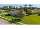 A well-maintained house sits on a lush green lawn, showcasing its inviting curb appeal in a serene neighborhood at 1860 Turnbull Lakes Dr, New Smyrna Beach, FL 32168