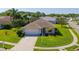 Charming single-Gathering home features lush lawn, mature landscaping, and a paved driveway leading to a two-car garage at 1860 Turnbull Lakes Dr, New Smyrna Beach, FL 32168