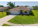 Charming single-story home with a well-manicured lawn, tropical landscaping, and a paved driveway at 1860 Turnbull Lakes Dr, New Smyrna Beach, FL 32168