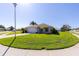 Well-maintained single-story home with lush lawn and mature landscaping under a bright blue sky at 1860 Turnbull Lakes Dr, New Smyrna Beach, FL 32168
