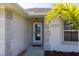 Close-up of the front door with decorative trim and house number, framed by palm trees at 1860 Turnbull Lakes Dr, New Smyrna Beach, FL 32168