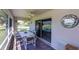 Screened lanai featuring an outdoor dining set, ceiling fan, and views of the lush landscaping at 1860 Turnbull Lakes Dr, New Smyrna Beach, FL 32168