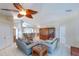 Bright living room with tile floors, a unique ceiling fan, and a view of the kitchen bar at 1860 Turnbull Lakes Dr, New Smyrna Beach, FL 32168