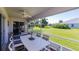 A screened-in lanai features a dining table and ceiling fan, perfect for outdoor enjoyment and relaxation at 1860 Turnbull Lakes Dr, New Smyrna Beach, FL 32168