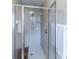 Close-up of a tiled shower with a glass door and a built-in seat at 1860 Turnbull Lakes Dr, New Smyrna Beach, FL 32168