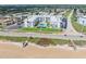 Aerial view of a condo complex on a green lawn near a sandy beach and ocean at 1926 Ocean Shore Blvd # 3050, Ormond Beach, FL 32176