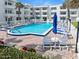 The pool is surrounded by lounge chairs and lush landscaping near the condo complex at 1926 Ocean Shore Blvd # 3050, Ormond Beach, FL 32176