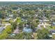 Aerial view showing mature trees and other homes in the area, along with a body of water in the distance at 1927 Orange Tree Dr, Edgewater, FL 32141